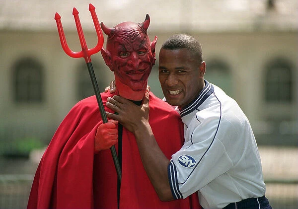Tottenham Hotspur striker Les Ferdinand poses with a Manchester United Red Devil