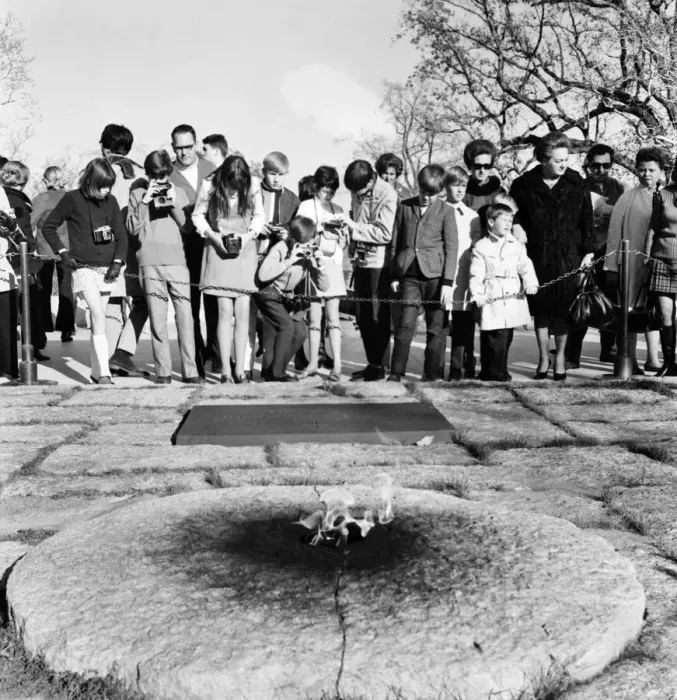 Framed Print : Tourists with their cameras observe the eternal flame at the grave of slain American