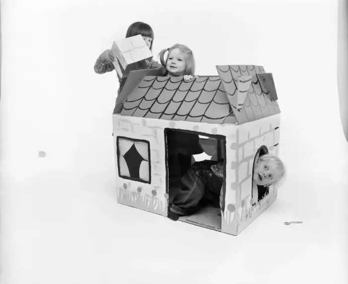 Framed Print : Toys: Children playing with a Wendy house made out of cardboard Framed Print : Toys: Children playing with a Wendy house made out of cardboard