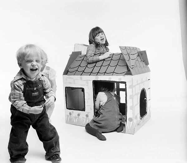 Toys: Children playing with a Wendy house made out of cardboard