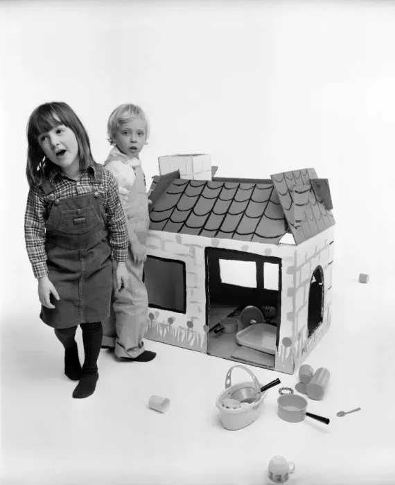 Framed Print : Toys: Children playing with a Wendy house made out of cardboard