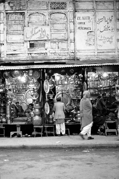 Traders Ironmongers sit inside their shops in Peshawar amongst the pots and pans