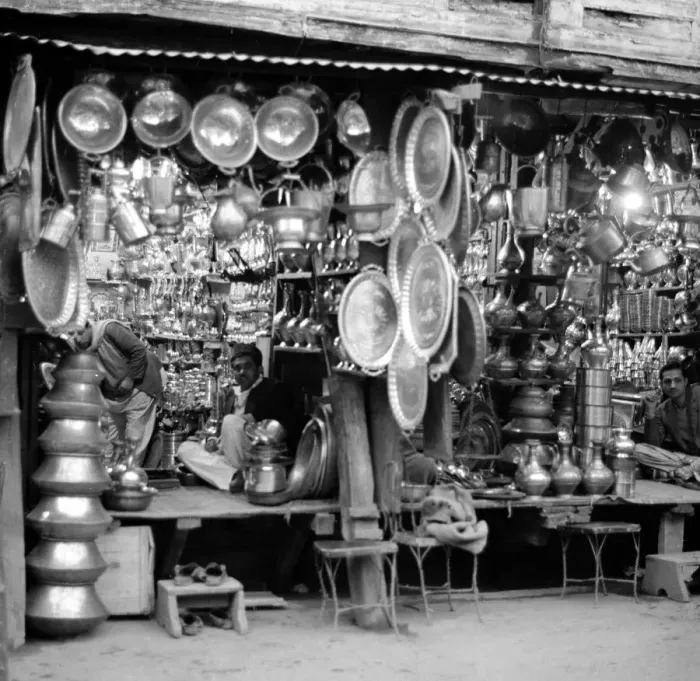 Framed Print : Traders Ironmongers sit inside their shops in Peshawar amongst the pots and pans
