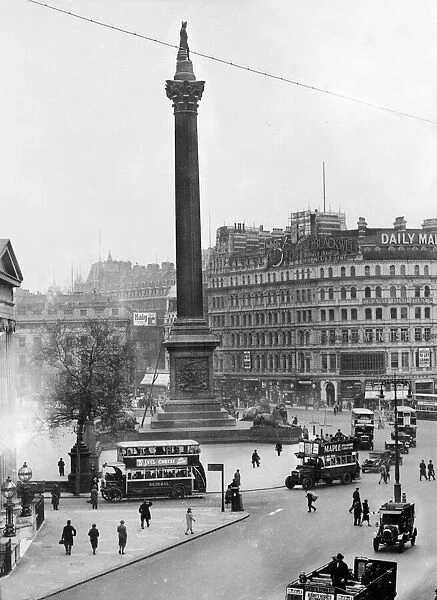 Trafalgar Square in London. Buses carry passengers around the square and Nelson