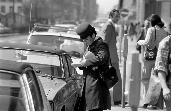 A traffic warden putting a ticket on a car without a tocket during her patrol