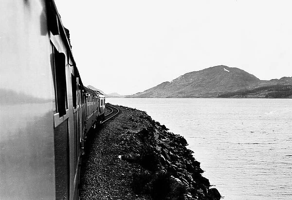 A train on the banks of a loch on the Inverness-Kyle of Lochalsh railway line circa 1962