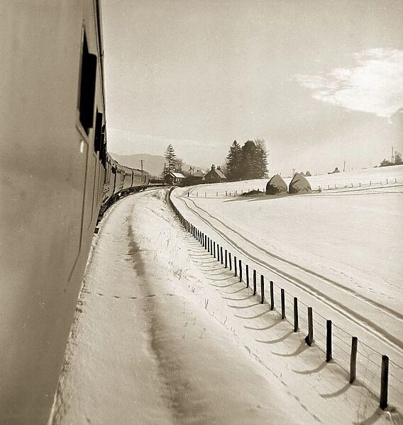 A train makes its way along the snow covered tracks as it travels from Perth northwards