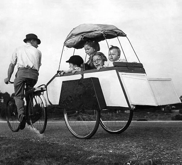 Transport: Cycles: Four of the family in the trailer. Baby Sonia age 10 months
