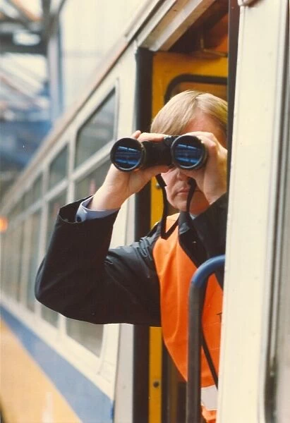 A transport police officer scans the tracks with his binoculars