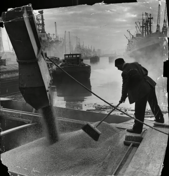 Framed Print : Trimming the cargo as grain roars down a chute from silo to barge in King George Dock Framed Print : Trimming the cargo as grain roars down a chute from silo to barge in King George Dock