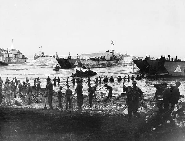 Troops unloading at Anzio. Men up to their waists in water, unloading stores
