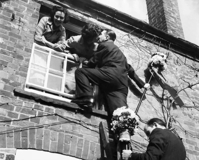 Framed Print : The tutti-men climb a ladder to get the traditional kiss the window during the Hock-tide Framed Print : The tutti-men climb a ladder to get the traditional kiss the window during the Hock-tide