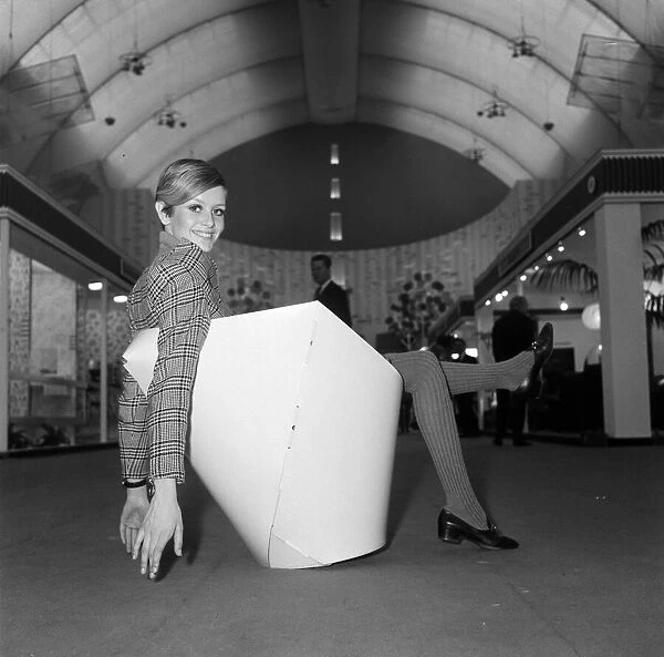 Twiggy sitting in a paper chair at the Ideal Home Exhibition. 6th March 1967