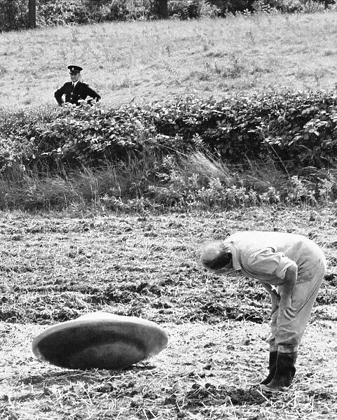 UFO being inspected by farmer Jennings after landing in his field whilst a police officer