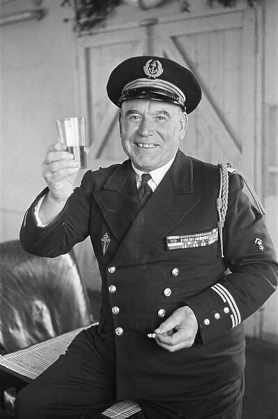 Un-named Free French Naval Captain poses with a drink for the press at their barracks in