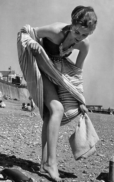 Undressing on the beach with the aid of a towel his been made easy by the simple device
