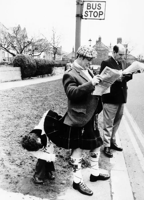 Framed Print : Unusual Picture of young boy satisfying his curiosity by peering under Scotsmans kilt Framed Print : Unusual Picture of young boy satisfying his curiosity by peering under Scotsmans kilt