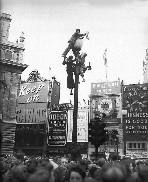 VE Day celebrations in London at end of WW2 people on a lamp post
