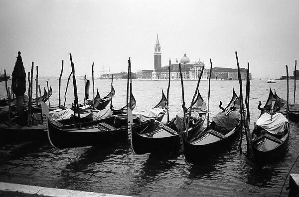 Venice, Italy: Gondolas and gondoliers on a rainy day. June 1965
