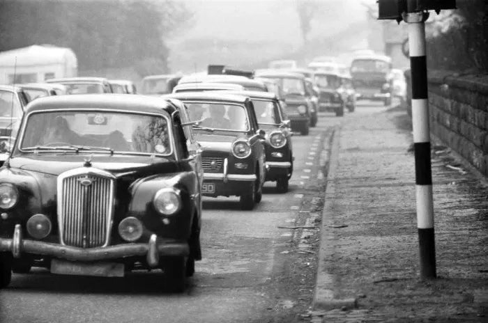 Framed Print : A view from the pavement as traffic is built up along the A556 towards Manchester