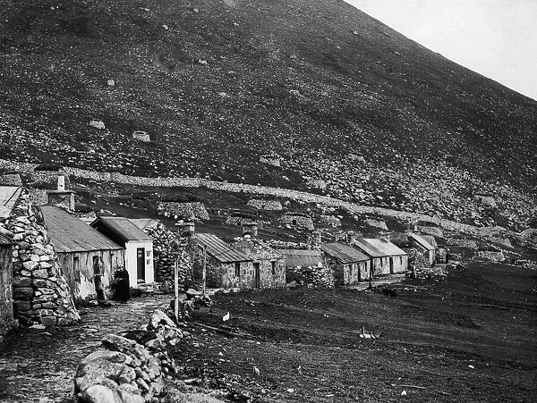 The village of St Kilda nestling at the foot of a bare rugged rock on the main island of