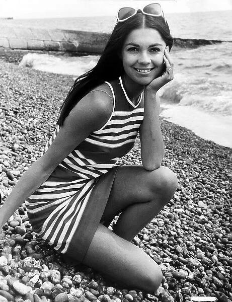 Virginia North Model posing on the beach in a striped dress resting her chin