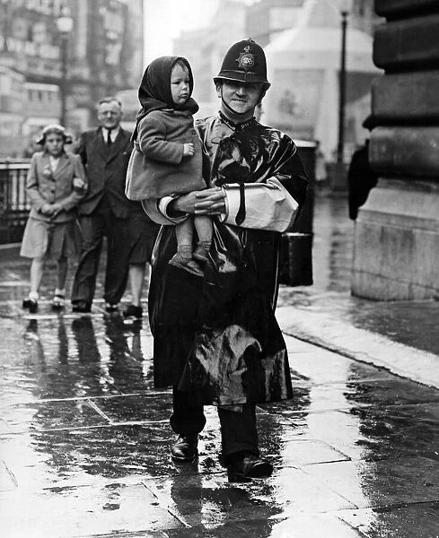 VJ Day, a policeman carries a lost child in Trafalgar Square, London. 15th August 1945