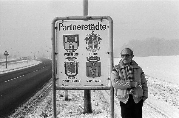 Volkswagen assembly line worker Peter Schredewitz leaning against the Wolfsburg town sign