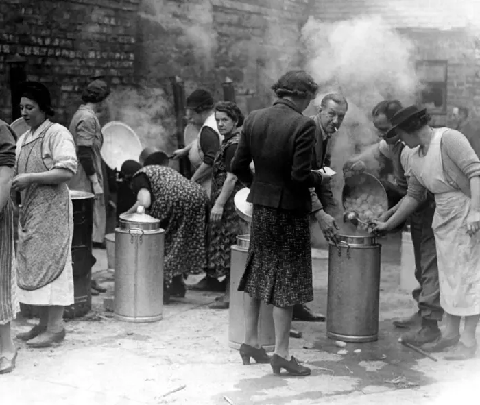 Framed Print : Volunteer workers prepare a meal for families rendered homeless by an air raid