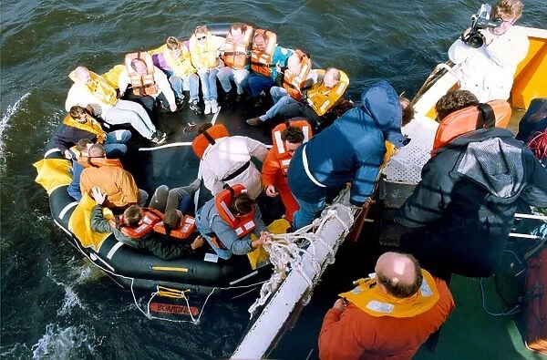 Volunteers clamber into the new life raft during a mock evacuation of the cross Tyne