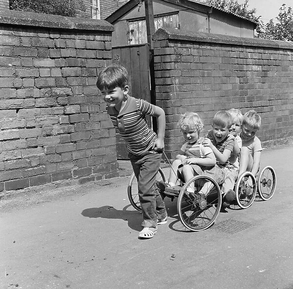 Wagons Roll. A young boy pulls his friends along, on a home made go kart. 1st August 1963