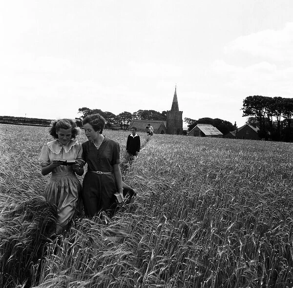 Walking through the barley field at Bigbury, South Devon Choirgirls Hannah (left