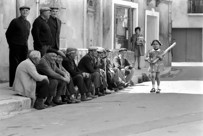 Framed Print : Walking past the old men of Poussan is 6 year old Nathalie Rustan carrying her French Framed Print : Walking past the old men of Poussan is 6 year old Nathalie Rustan carrying her French