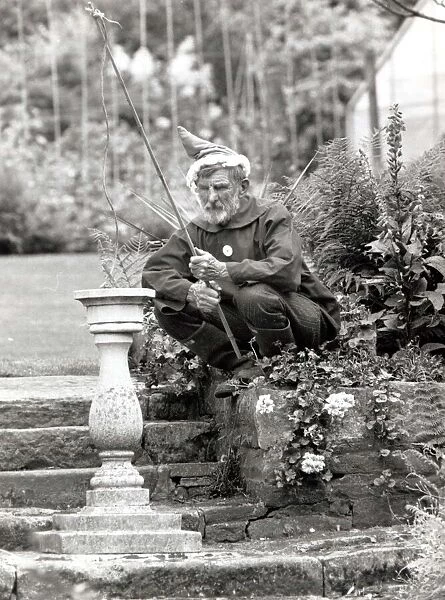 Walter Sherratt, aged 67, is posing as a garden gnome in his garden at Biddulph