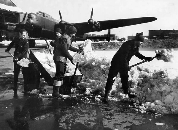 Warmly clad members of Ground Crew clearing away snow from a dispersl point at a bomber
