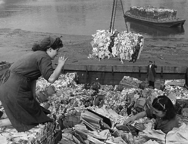 Waste paper salvage girls at work on the side of the River Thames
