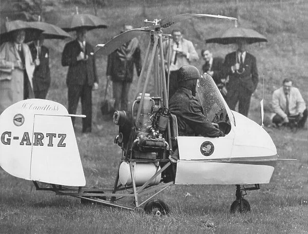 Watched by Prince Philip, autogyro pilot Rex McCandless begins his take-off in a field