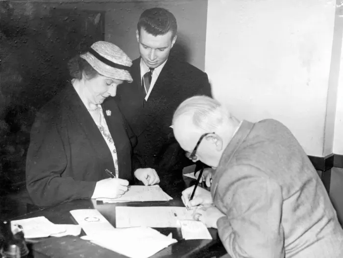 Framed Print : Welsh Athlete Hywel Williams watches as his widowed mother Mrs Olwen Williams pay for his