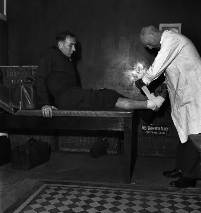 Framed Print : West Bromwich Albion F. C. Trainer Fred Read bandages ankle of footballer Billy Elliot
