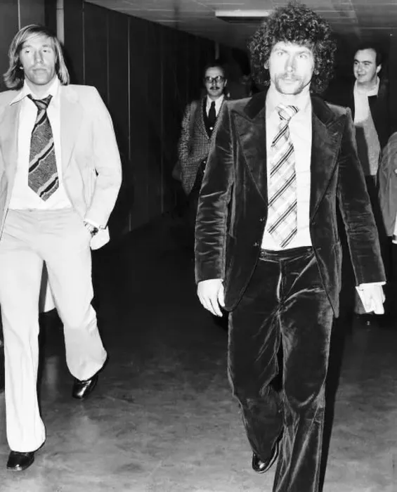 : West German footballer Paul Breitner on his way through Heathrow Airport with fellow : West German footballer Paul Breitner on his way through Heathrow Airport with fellow