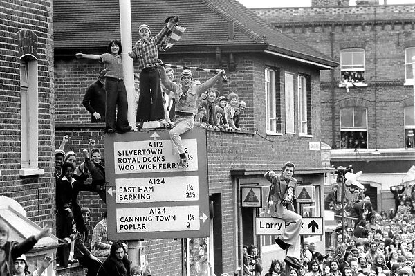 West Ham fans try to get a good view above the crowds during the West Ham victory parade