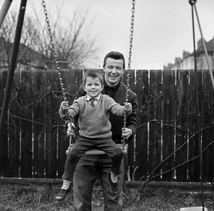 Framed Print : West Ham footballer Johnny Byrne celebrates his England call up with a swing with his son Framed Print : West Ham footballer Johnny Byrne celebrates his England call up with a swing with his son