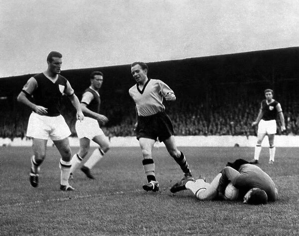 West Ham goalkeeper, Gregory, dives to smother the ball as Norman Deeley
