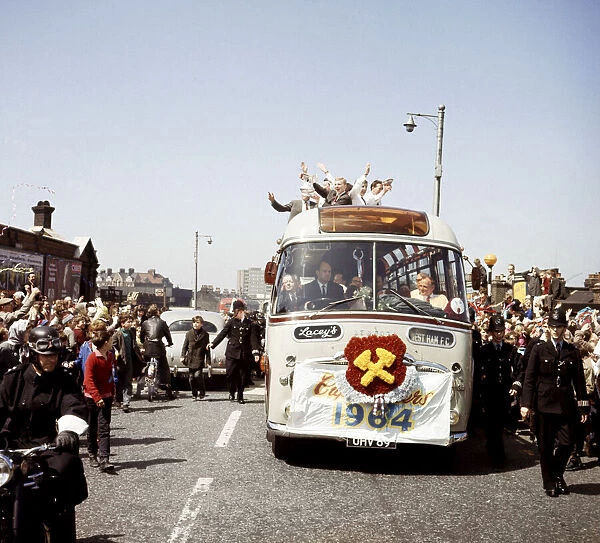 West Ham United captain holds aloft the FA Cup from an open top double decker bus as