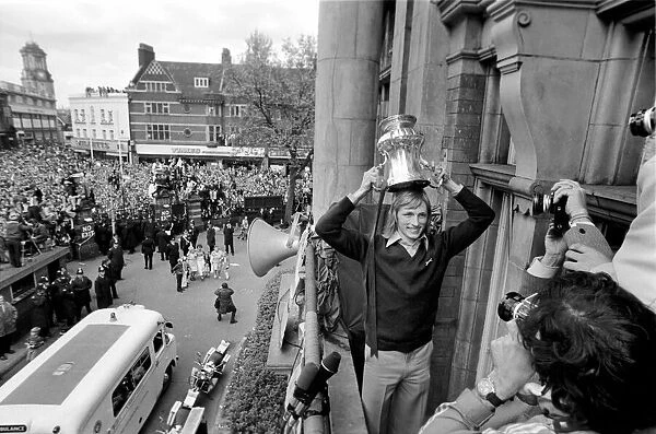 West Hams Alan Taylor showing off the trophy to fans gathered below at Newham Town