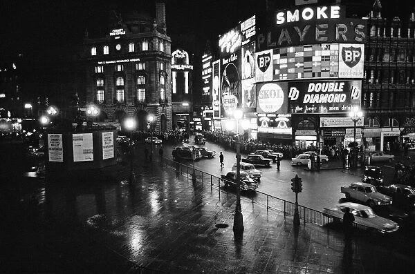 A wet and busy Piccadilly Circus, London, United Kingdom, at night