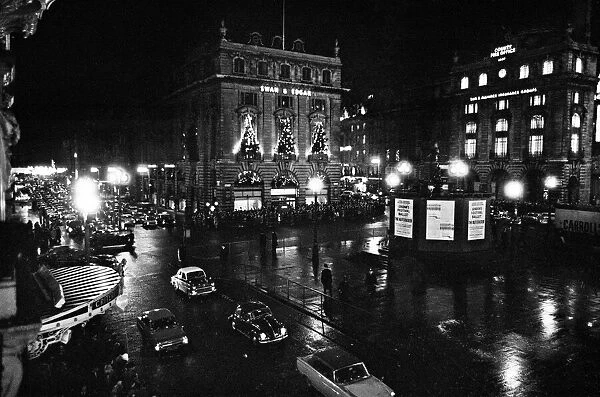A wet and busy Piccadilly Circus, London, United Kingdom, at night
