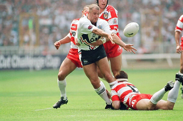 A Widnes player is pounced upon by three of the Wigan defence during the Rugby League Cup
