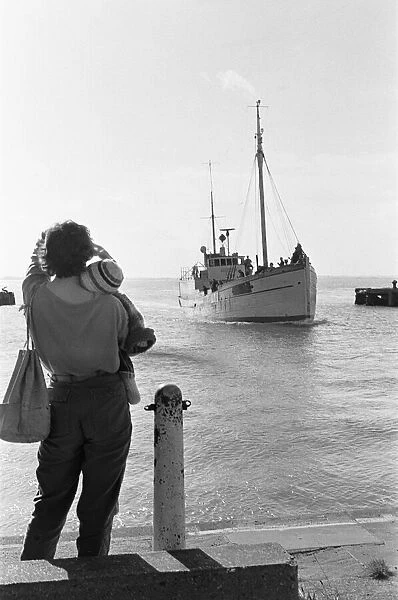The wife and young child of one of the crew of the fishing vessel William McCann waits