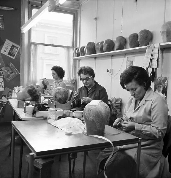 Wigmakers Workshop: Women making wigs whilst in another part of the workshop hair is